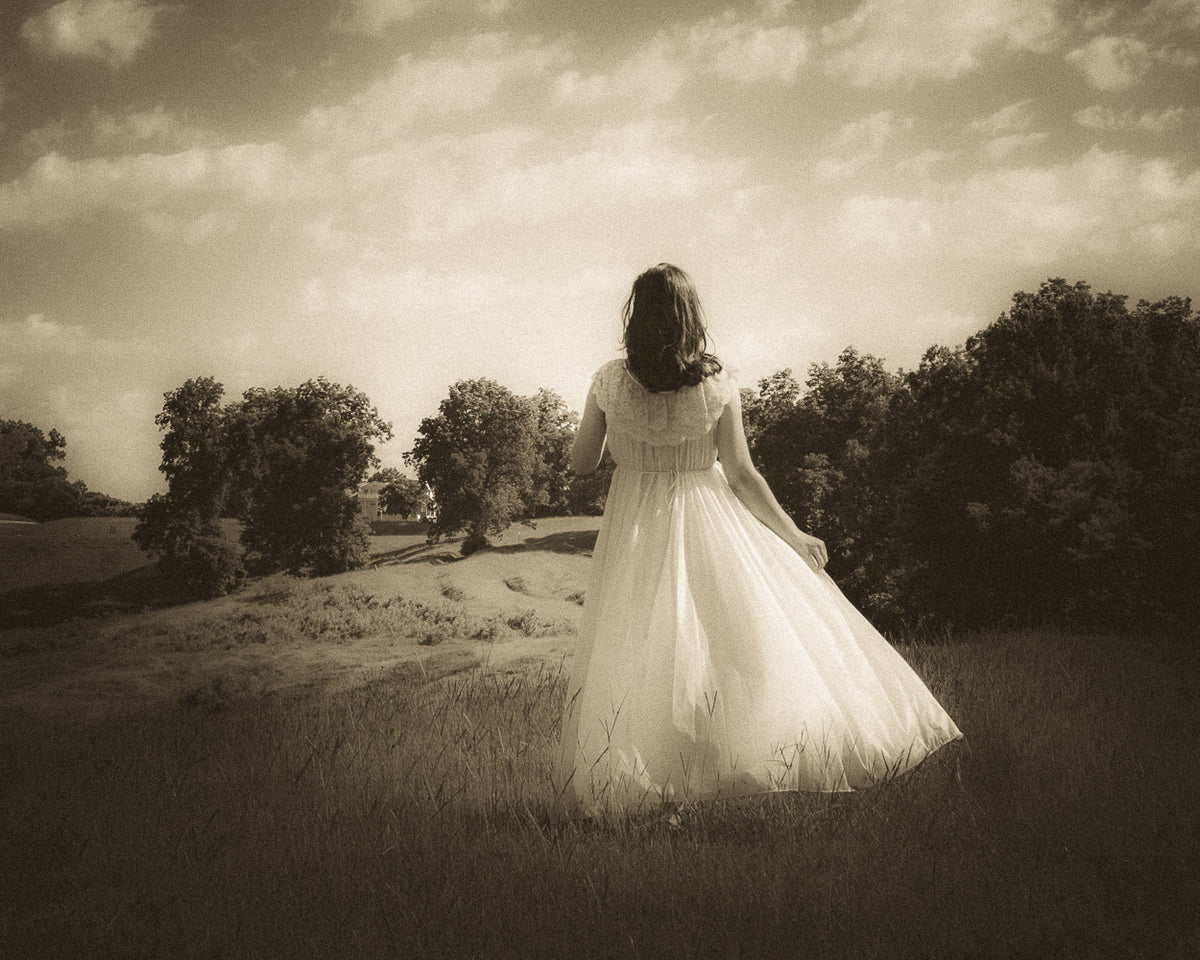 Figure in a flowing white dress in a field beneath a cloudy sky at Vicksburg National Park, photographed by J. Durr Wise