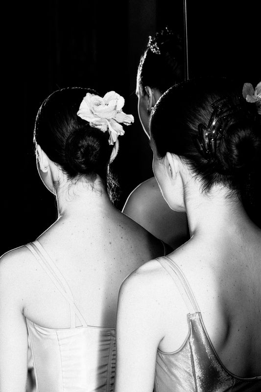 Three dancers standing together beyond the audience's view, their faces hidden